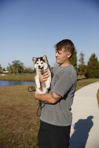 Jacob Soos with a young dog during puppy training in Parrish, Florida