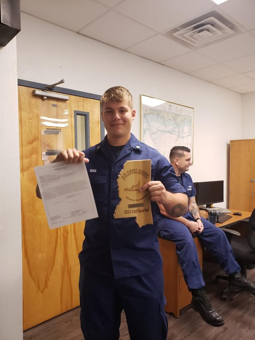 Jacob Soos in U.S. Coast Guard uniform holding service paperwork